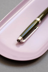 Caran d’Ache Terre d’Ombre fountain pen with a silver clip on a pink Lola stand.