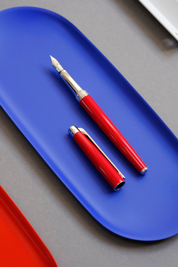 Caran d’Ache Léman Slim fountain pen in red on a blue Lola stand by Notem.