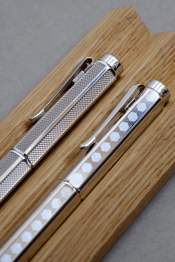 Caran d'Ache Ecridor Milanese Mesh and Heritage fountain pens on an oak pen stand.