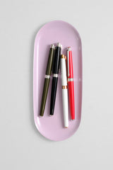 Four Caran d’Ache Léman Slim fountain pens in green, black, white, and red.