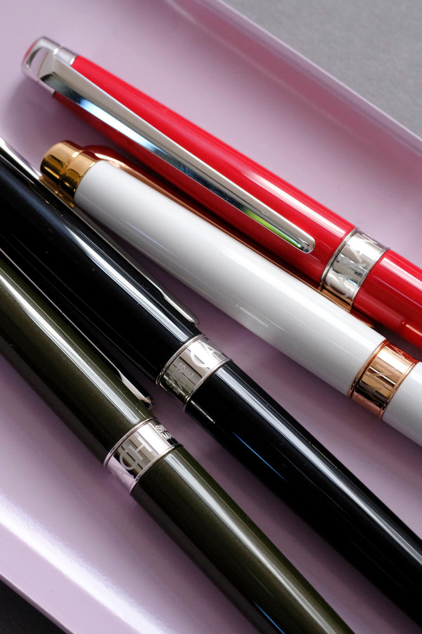 Details of Caran d’Ache Léman Slim fountain pens in green, black, white, and red.