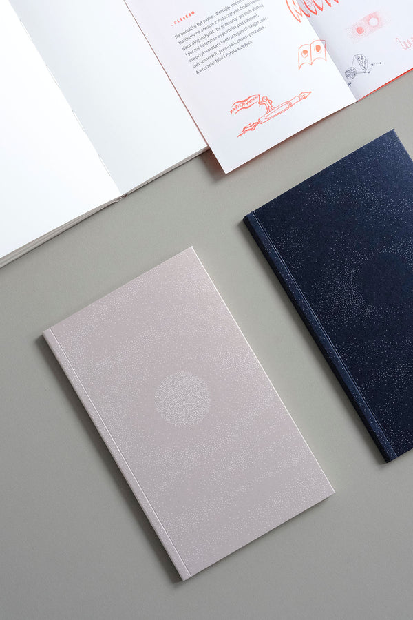 A5 slim-format notebooks with a soft cover in beige and navy blue, plain inside.