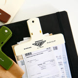 A cream-colored plastic paper clip holding receipts together.