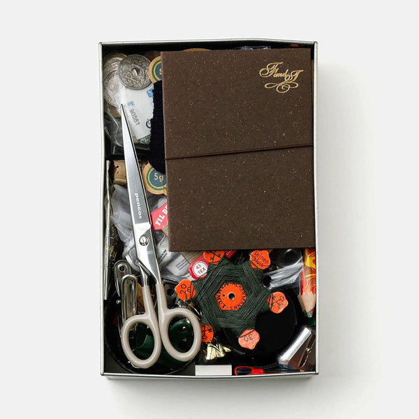 Steel scissors with ivory handles and the Penco brand name engraved on them in the box.