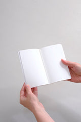An open pocket-sized notebook from the Luna collection with plain pages inside.